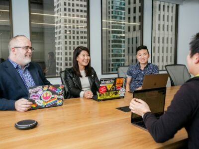 A diverse group of professionals engaged in a collaborative discussion around a table, symbolizing teamwork, resilience, and innovative leadership in the workplace.